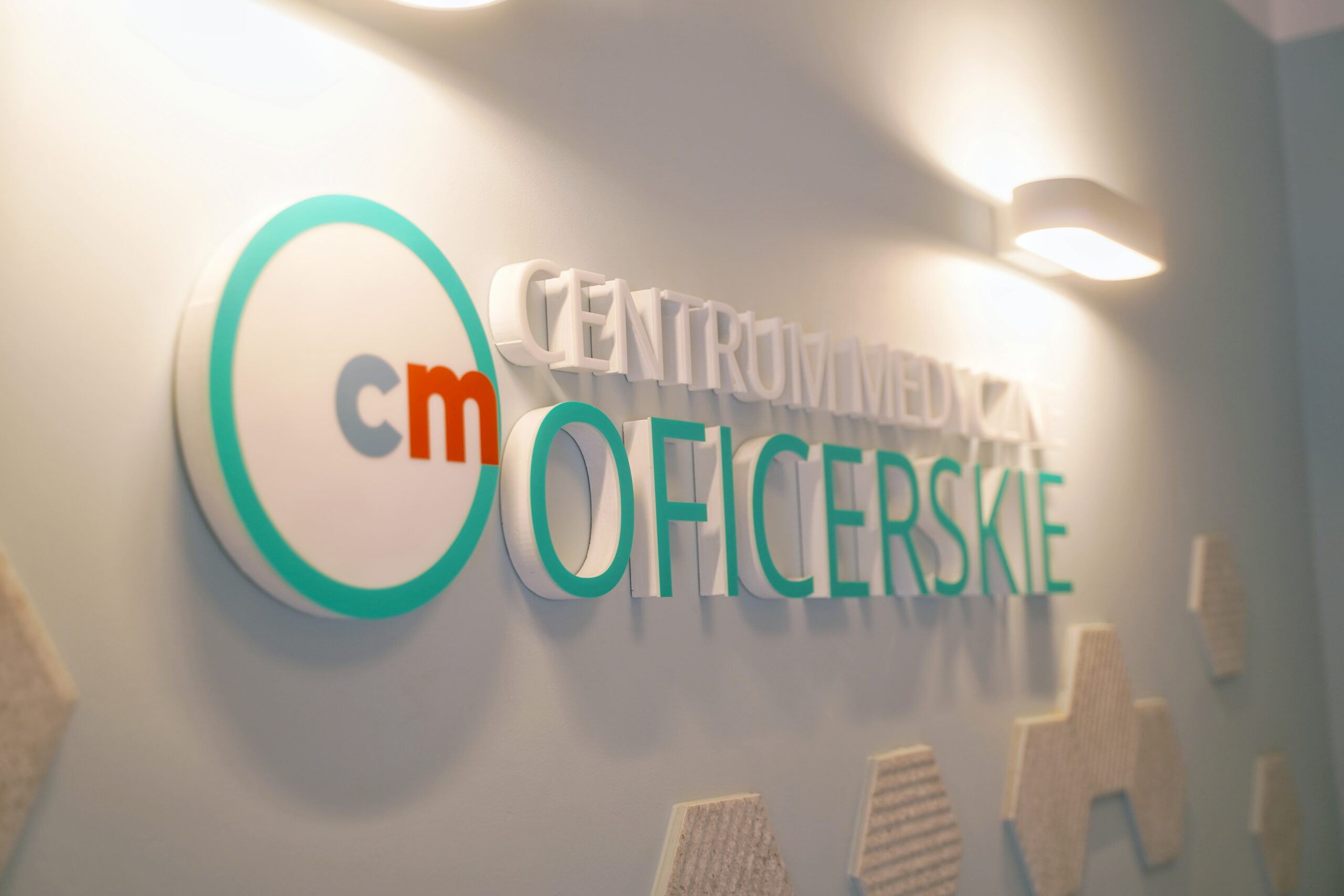 Logo Centrum Medycznego Oficerskie wyeksponowane na ścianie recepcji